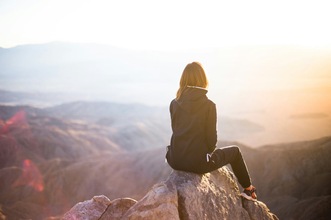 A woman on a mountaintop admiring the view.